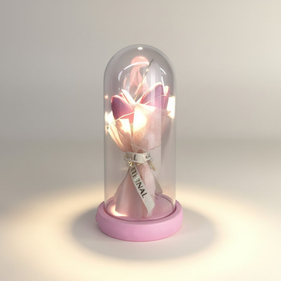 eRamis pink preserved tulips in a glass dome with a pink base and ribbon that says ETERNAL.