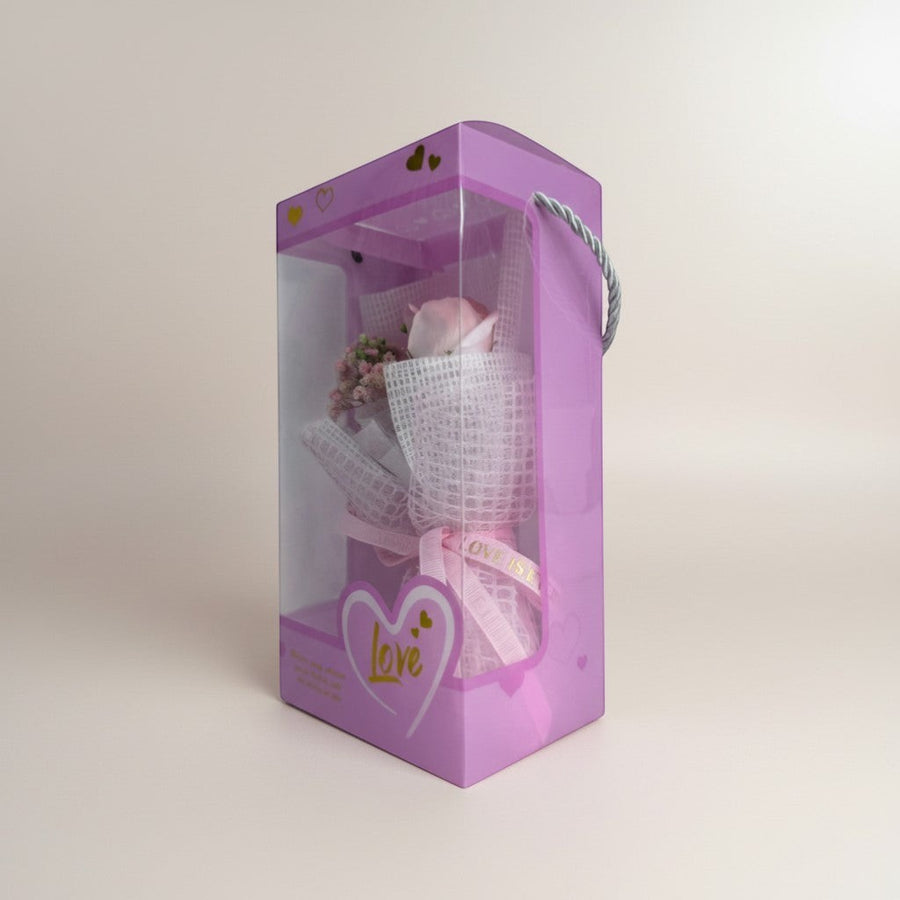 eRamis pink rose bouquet with small pink flowers, wrapped in white mesh and pink ribbon, presented in a purple gift box with heart designs.
