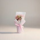 eRamis pink roses and baby's breath bouquet with white mesh wrap and pink ribbon.