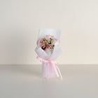 eRamis pink roses and baby's breath bouquet wrapped in white mesh and tied with a pink ribbon.