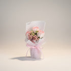 eRamis pink and white roses bouquet with baby's breath, wrapped in white mesh and tied with a pink ribbon.