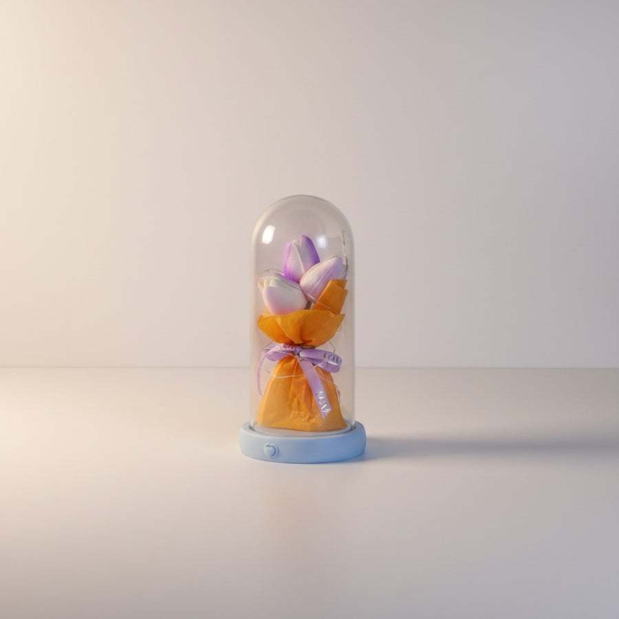 eRamis preserved purple and white tulips under a glass dome with fairy lights and a blue base.