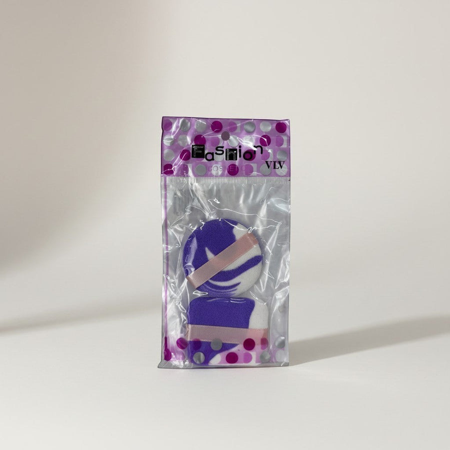 eRamis purple and white makeup sponges, one round and one rectangular, with pink ribbon accents.