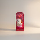 eRamis white plush teddy bear with pink skirt and heart gem, holding 'I Love You' sign, next to a pink galaxy rose in gift box.