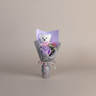 eRamis white teddy bear bouquet with purple rose, pink flower, and pearl accents, tied with a love heart ribbon.