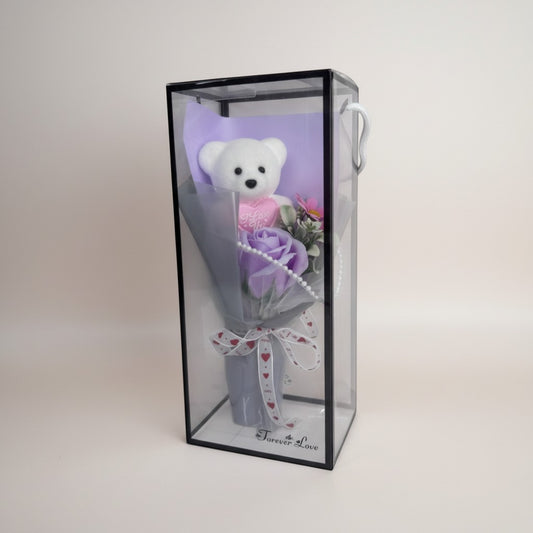 eRamis white teddy bear with pink heart saying "I Love You", purple rose bouquet, and decorative pearls in a clear box.