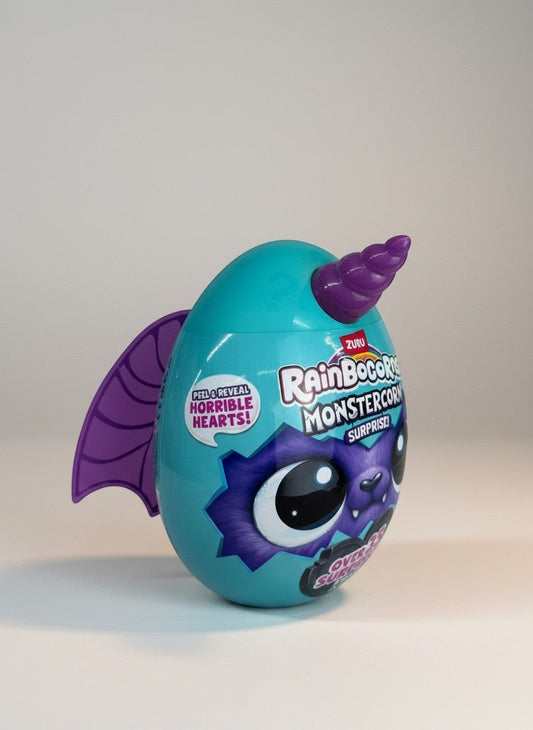 eRamisHere Monstercorn Surprise teal egg with purple bat wings and horn, featuring a furry monster eye. Peel & Reveal Horrible Hearts!