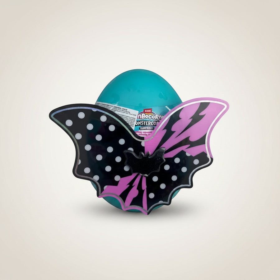 eRamisHere Monstercorn Surprise Egg in teal with black and pink monster wings and a bat emblem. Includes plushie and over 35 surprises.