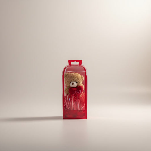 eRamisHere small teddy bear holding a pink heart with 'LOVE' text, presented in a red gift box with iridescent red shred.