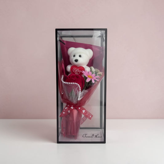 eRamisHere white teddy bear with red rose and pink flower bouquet in a clear box with red ribbon.