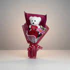 eRamisHere white teddy bear bouquet with red rose and pink flower, adorned with pearls and red ribbon.