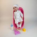 eRamis baby doll in pink bathtub wearing polka dot robe and hat, with bottle, washcloth, and rubber ducky.