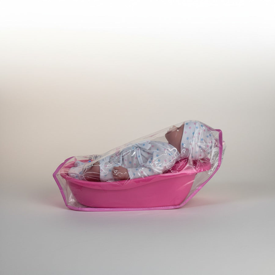 eRamis baby doll in pink polka dot outfit in a pink bathtub with accessories, ready for bath time play.