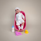 eRamis baby doll in pink polka dot robe and hat, with bathtub, bottle, washcloth, and rubber ducky.