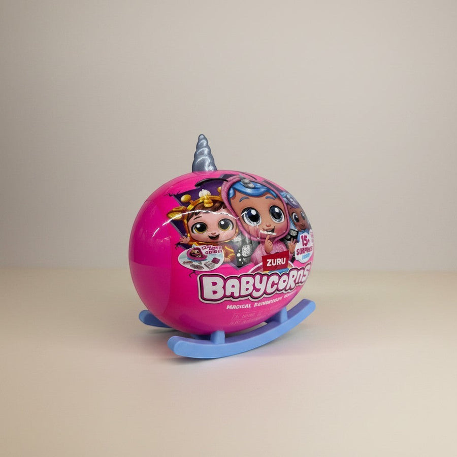 eRamis Babycorns magical surprise toy in a pink sphere with unicorn horn and blue rocking base.