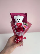 eRamisHere white teddy bear holding a red heart with 'I Love You' text, with a red rose and pink flowers. Gift bouquet.