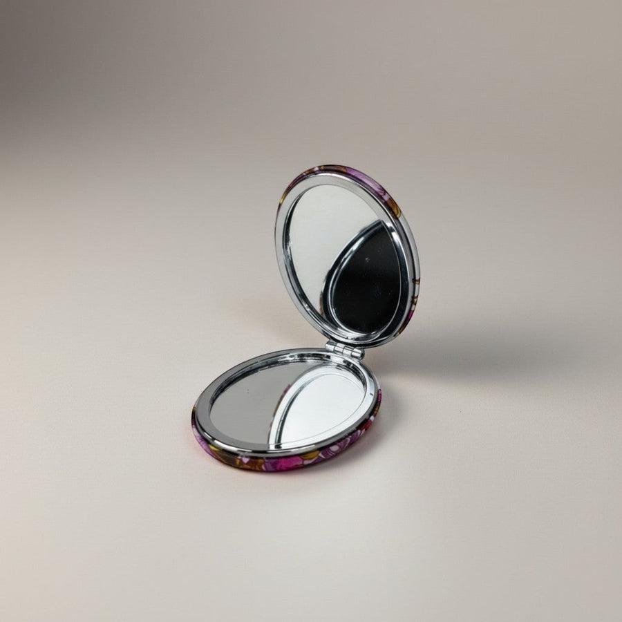 eRami round compact mirror with floral pattern and silver trim, perfect for makeup touch-ups.